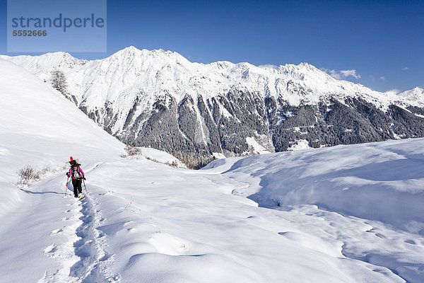 Schneeschuhwanderer beim Aufstieg zur Jagelealm im Ridnauntal oberhalb von Entholz  hinten das Ridnauntalm  der Rosskopf und die Telfer Weißen  Südtirol  Italien  Europa