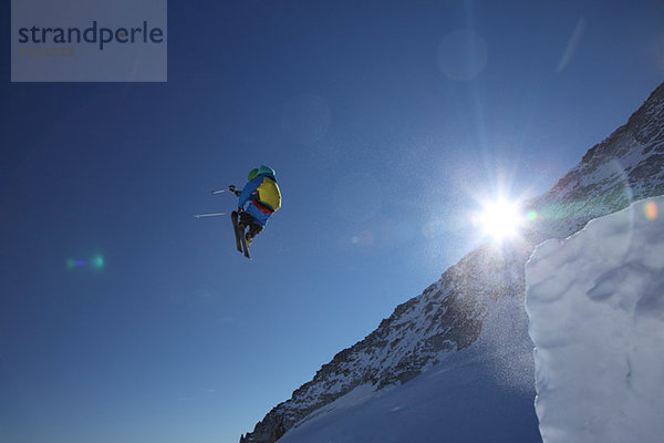 Männlichen Skifahrer Tigersprung gegen clear blue sky