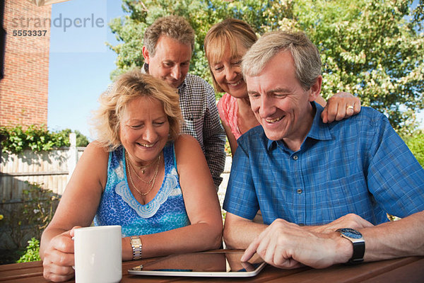 Senioren und reife Freunde beim Betrachten des digitalen Tabletts im Freien