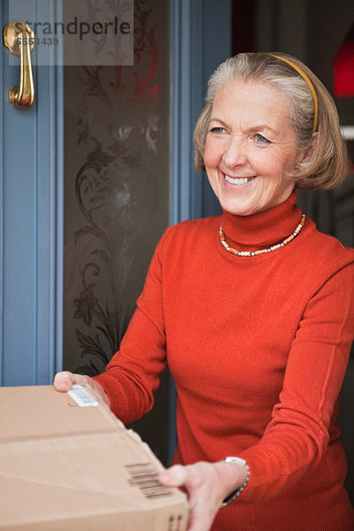 Seniorin erhält Paket vor der Haustür