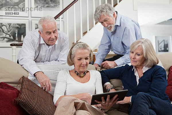 Seniorenfreunde mit digitalem Tablett