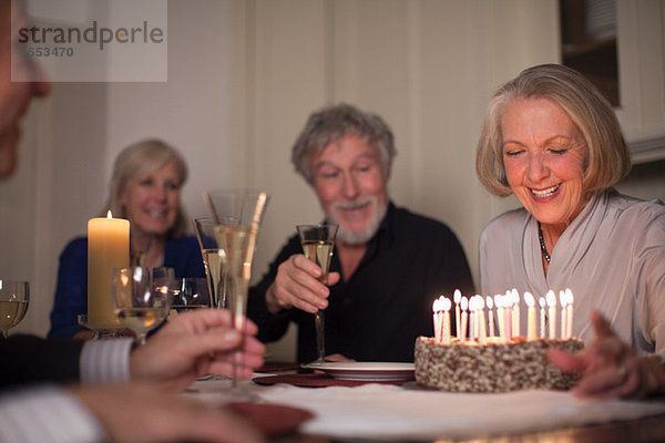 Seniorin und Freunde mit Geburtstagskuchen