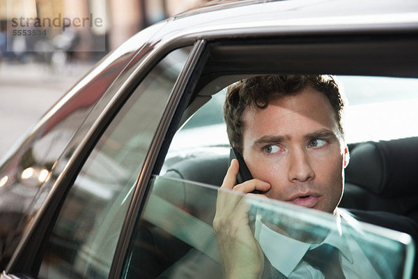 Businessman in Car auf Handy