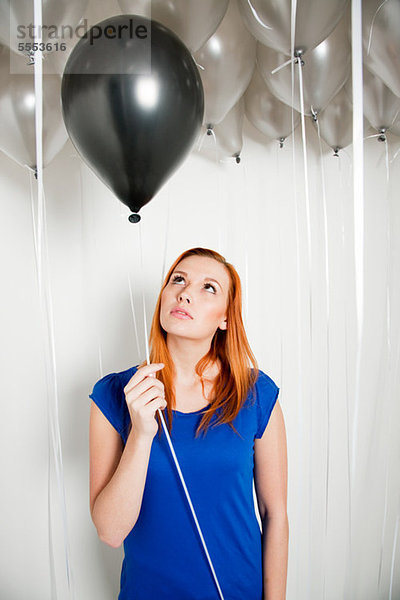 Junge Frau mit schwarzem Ballon