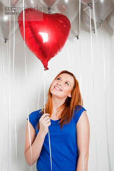 Junge Frau mit herzförmigem Ballon