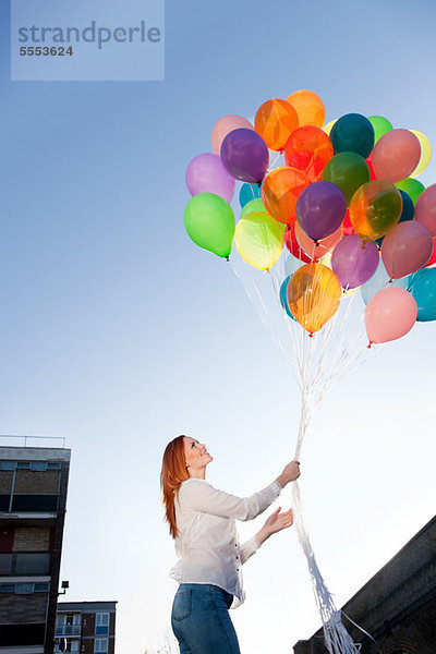 Junge Frau im Freien mit Luftballons