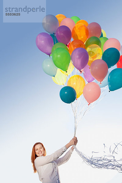 Junge Frau im Freien mit Luftballons