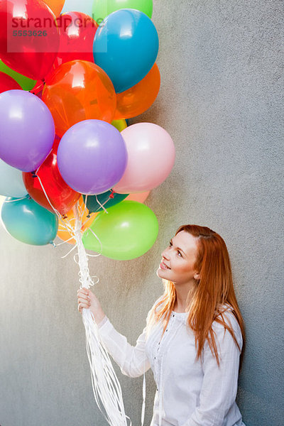 Junge Frau mit Haufen von Ballons