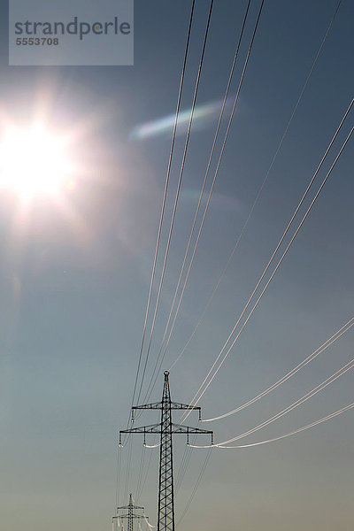Neu verlegte Stromleitungen an einem Hochspannungsmast im Sonnenlicht  Schleswig-Holstein  Deutschland