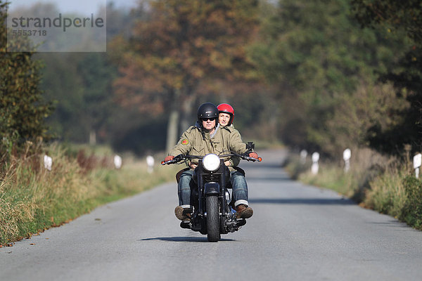 Paar fährt Motorrad auf einer Landstraße