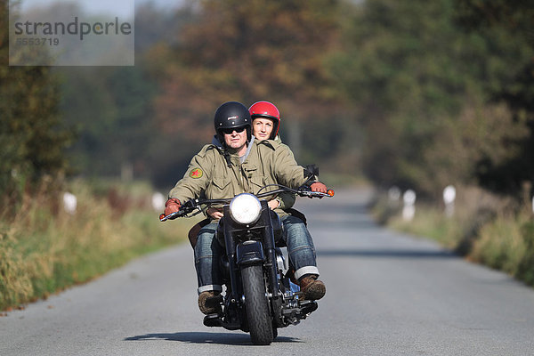 Paar fährt Motorrad auf einer Landstraße