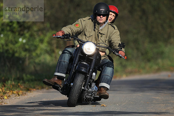 Paar fährt Motorrad auf einer Landstraße