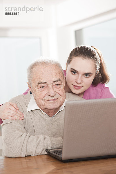 Junge Frau und Senior am Laptop