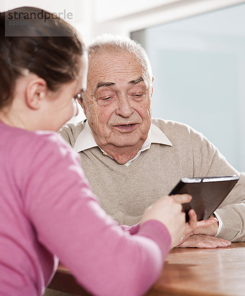 Junge Frau und Senior mit einem Tablet-PC