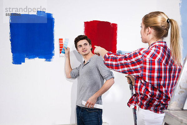 Junges Paar streicht eine Wand