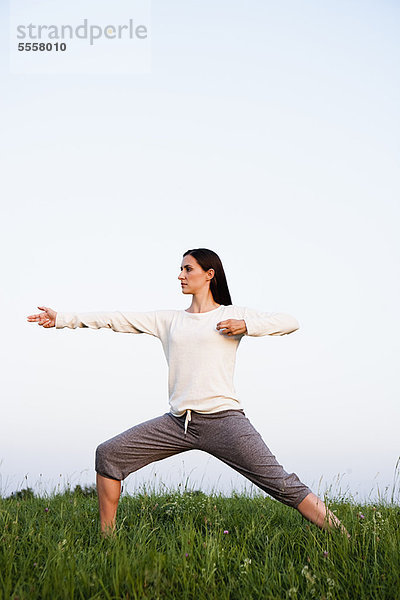 Frau praktiziert Yoga im Park