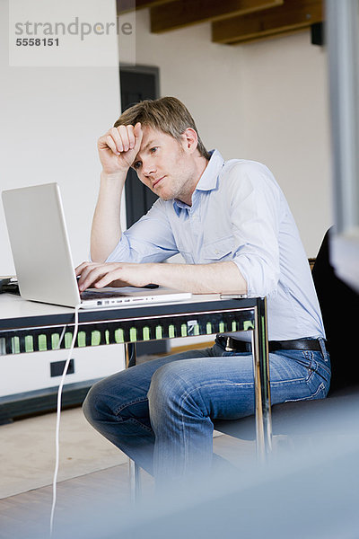 Geschäftsmann bei der Arbeit am Laptop