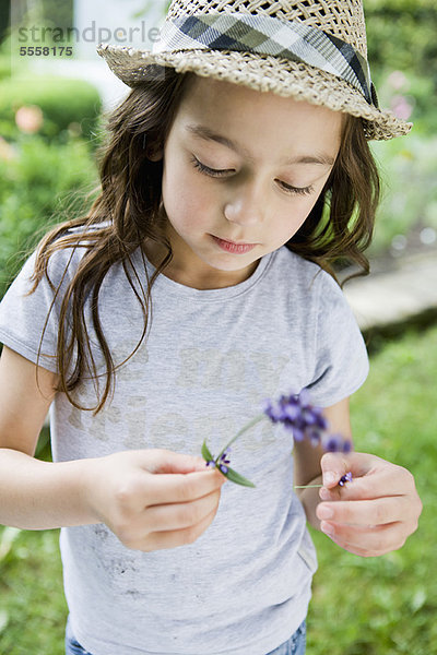 Mädchen untersucht Blume im Freien