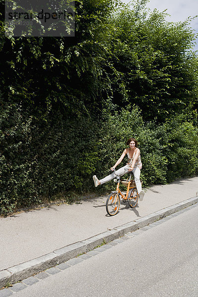 Frau beim Radfahren auf der Landstraße