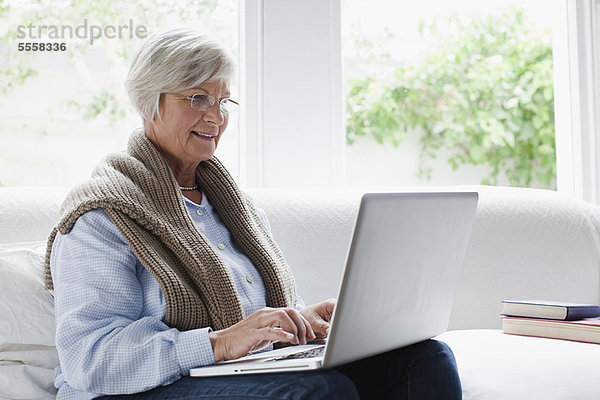 Lächelnde ältere Frau mit Laptop