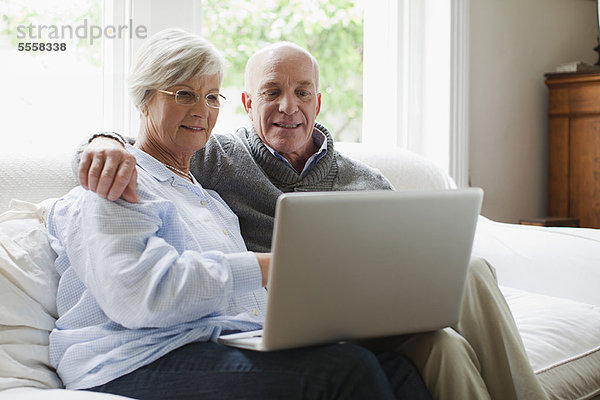 Lächelndes älteres Paar mit Laptop