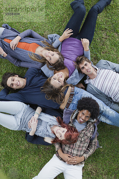 Studenten liegen im Gras auf dem Campus