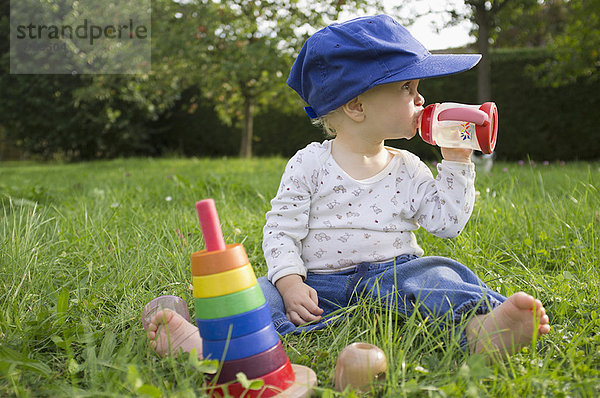 Baby trinkt Saft im Gras