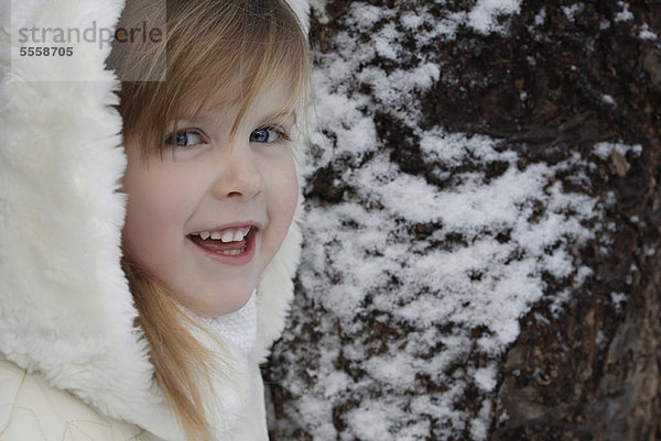 Lächelndes Mädchen steht draußen im Schnee