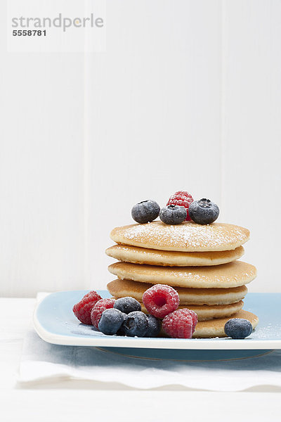 Beeren und Zucker auf Pfannkuchenstapel