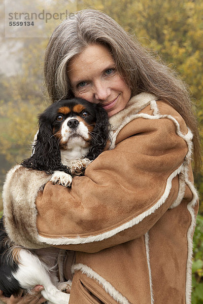 Außenaufnahme  Frau  umarmen  Hund  alt  freie Natur