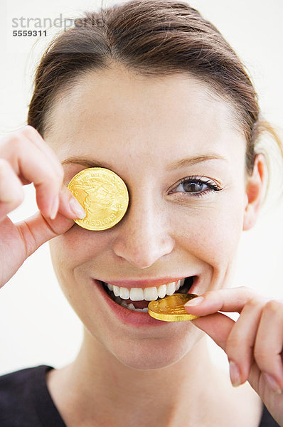 Frau spielt mit Goldmünzen