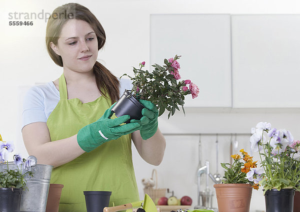 Frau deponiert Blumen im Haus