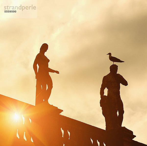 Silhouette der Statuen vor bewölktem Himmel