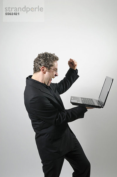 Geschäftsmann in schwarzem Anzug mit Laptop  Jubel