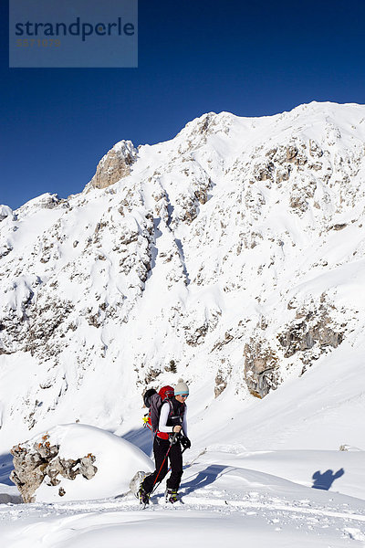 Skitourengeher oberhalb der Wörndle-Loch-Alm beim Aufstieg zum Zendleser Kofel im Villnösstal oberhalb der Zanser Alm  hinten die Aferer Geisler  Südtirol  Italien  Europa