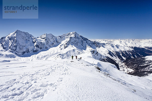 Skitourengeher beim Abstieg der hinteren Schöntaufspitze  Sulden  hinten die Königsspitze  der Zebru und Ortler sowie das Suldental  Südtirol  Italien  Europa