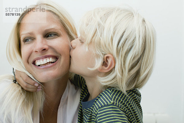 Junge küsst seine Mutter auf die Wange.