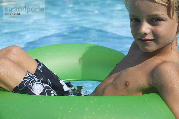 Junge entspannt auf dem Floß im Pool  Portrait