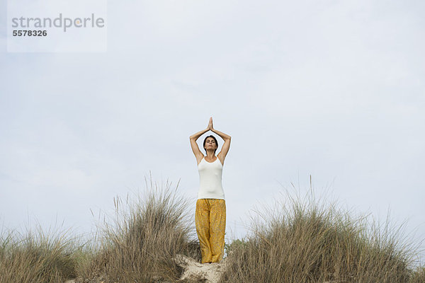 Reife Frau macht Sonnengruß-Yoga-Pose