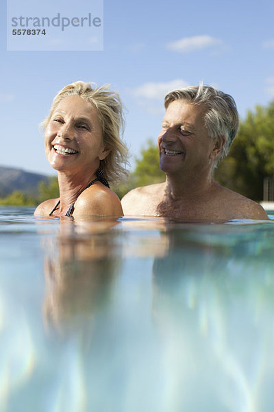 Reife Paare entspannen sich gemeinsam im Pool