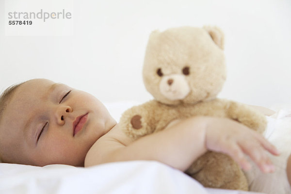 Baby schläft mit Teddybär