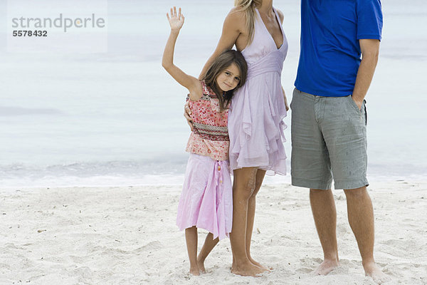 Mädchen und Eltern am Strand stehend  beschnitten