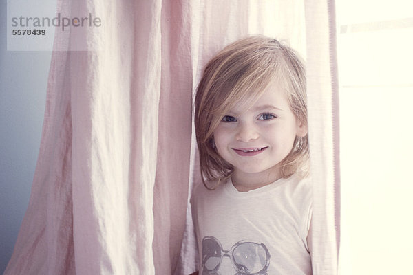 Kleines Mädchen vor dem Fenster  lächelnd  Portrait