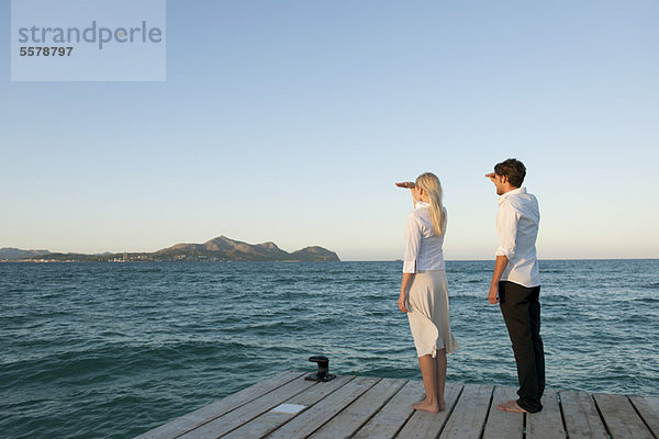 Paar auf dem Pier stehend mit Blick auf die Seitenansicht