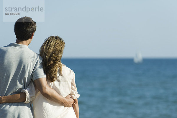 Paar am Strand  Blick aufs Meer  Rückansicht