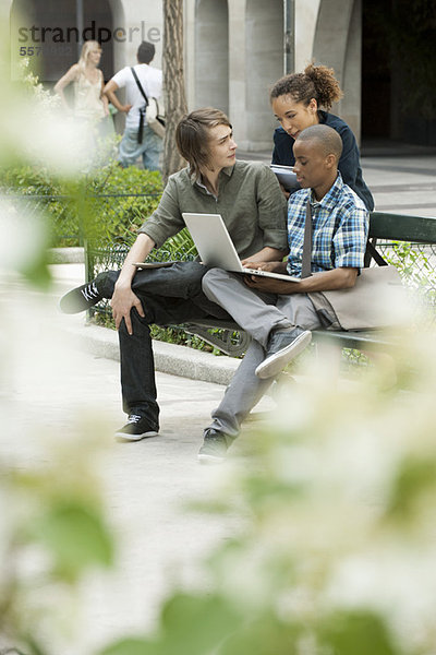 Universitätsstudenten  die auf dem Campus mit Laptop studieren