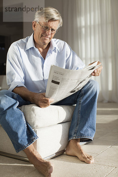 Älterer Mann entspannt sich mit Zeitung