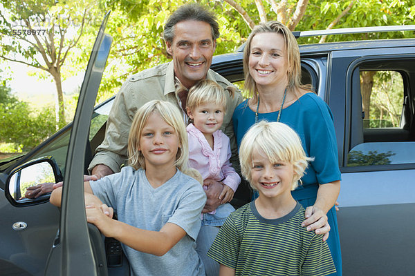 Familie posiert neben dem Auto  Portrait