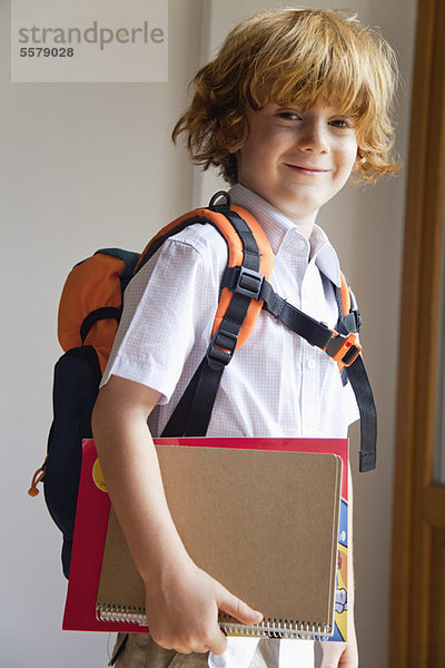 Junge vorbereitet für die Schule  mit Rucksack und Notizbüchern