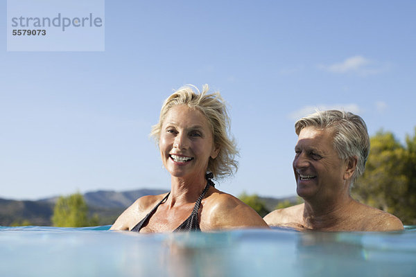 Reife Paare entspannen sich gemeinsam im Pool